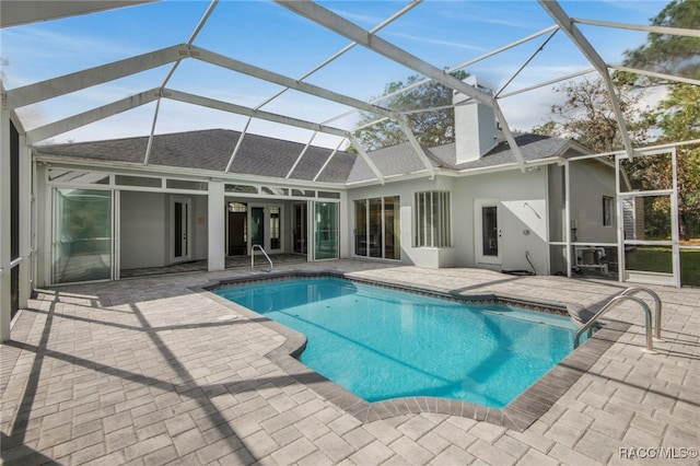 view of pool featuring glass enclosure and a patio area