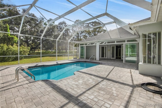 view of pool with a patio and glass enclosure