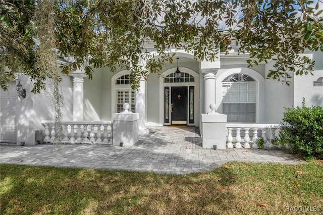 property entrance with a lawn