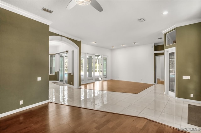 empty room featuring crown molding, ceiling fan, and light wood-type flooring