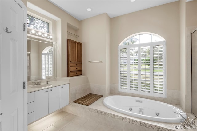 bathroom featuring tile patterned floors, vanity, and tiled bath