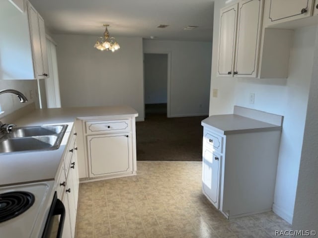 kitchen with sink, kitchen peninsula, pendant lighting, a chandelier, and white cabinets