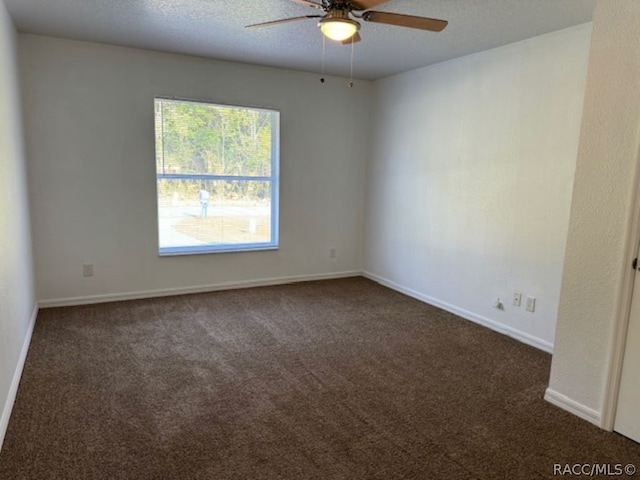 unfurnished room with dark colored carpet, a textured ceiling, and ceiling fan