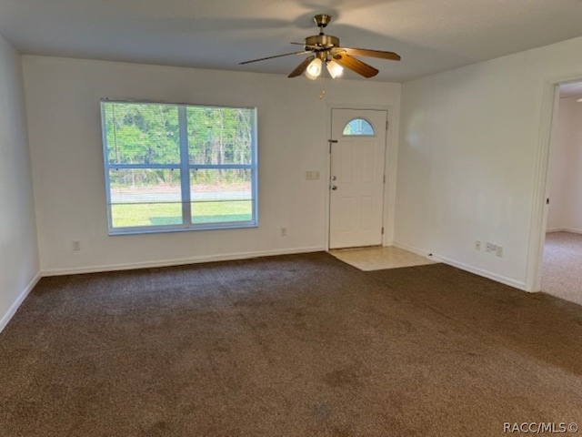 carpeted entryway with ceiling fan