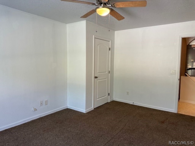 carpeted spare room with ceiling fan and a textured ceiling