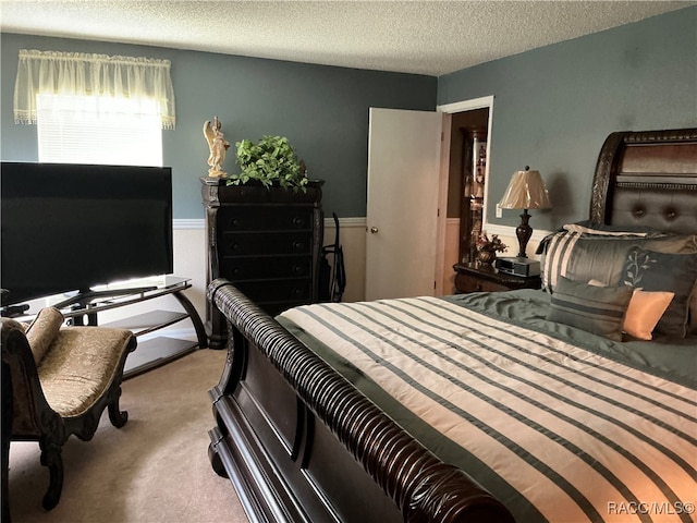 bedroom featuring a textured ceiling and light colored carpet