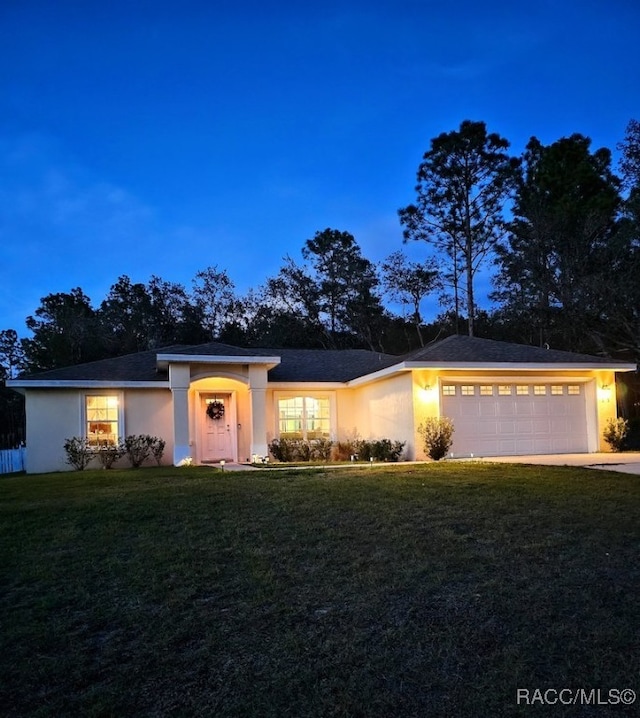 view of front facade with a garage and a yard