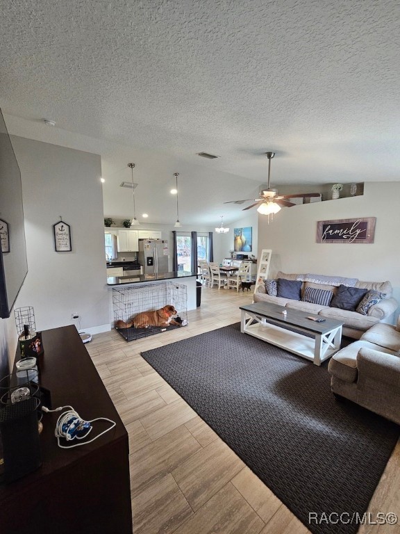 living room featuring a textured ceiling and ceiling fan