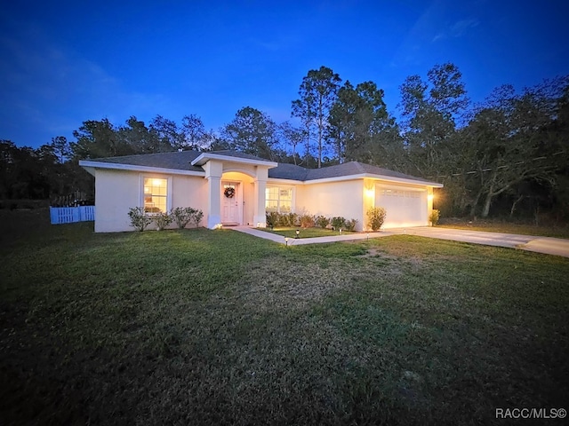 ranch-style home with a garage and a front lawn