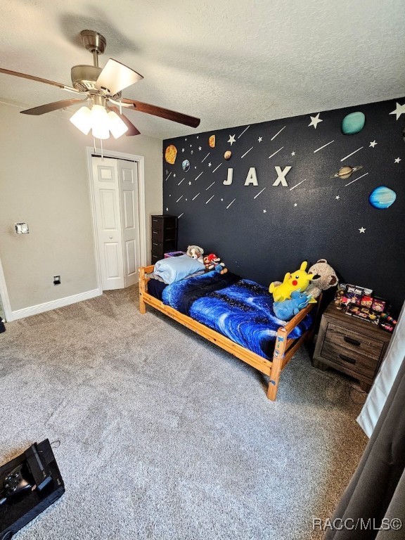 carpeted bedroom with a textured ceiling and ceiling fan