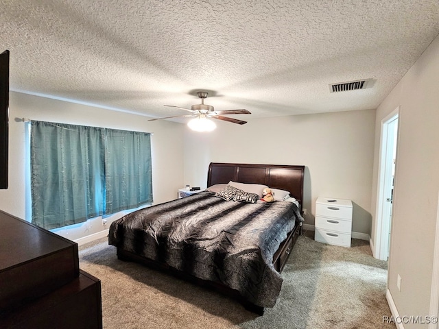 bedroom featuring a textured ceiling, carpet floors, and ceiling fan