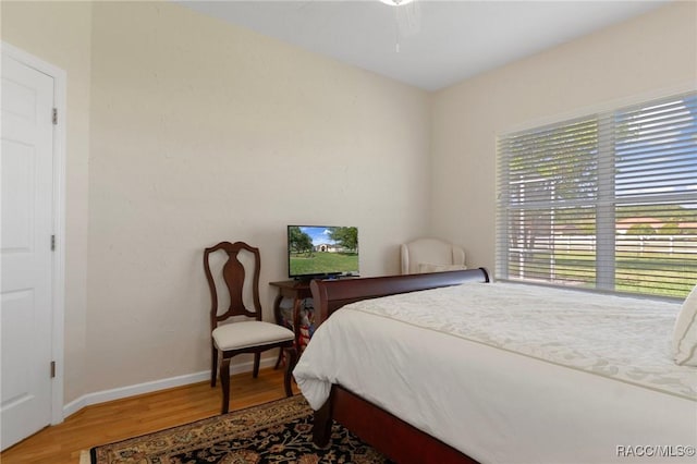 bedroom featuring baseboards, a ceiling fan, and light wood-style floors