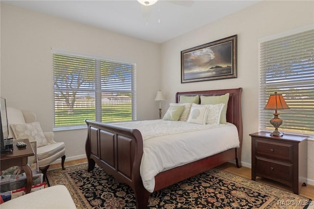 bedroom featuring wood finished floors, baseboards, and a ceiling fan