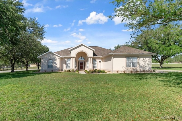 ranch-style house featuring a front yard and stucco siding