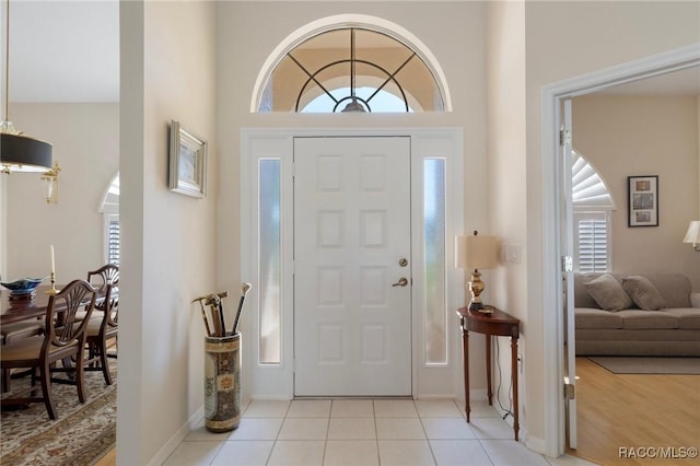 entryway with baseboards and light tile patterned flooring