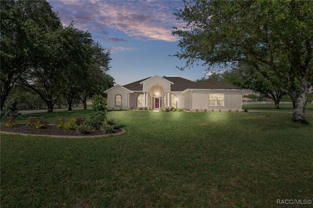single story home featuring a lawn and stucco siding