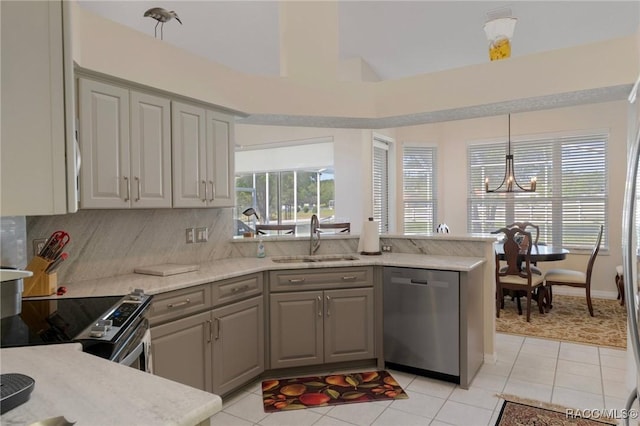 kitchen with light tile patterned floors, tasteful backsplash, appliances with stainless steel finishes, a sink, and gray cabinetry