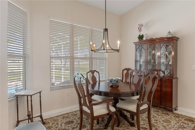 dining space featuring light tile patterned flooring, a notable chandelier, and baseboards