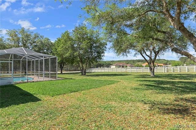 view of yard with a lanai, a fenced in pool, and fence