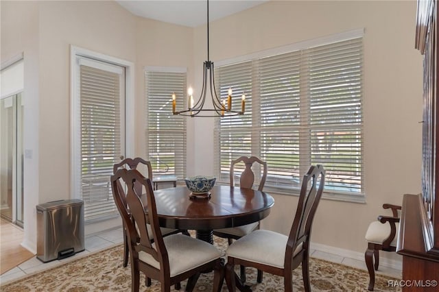 dining room featuring light tile patterned floors, a notable chandelier, and baseboards