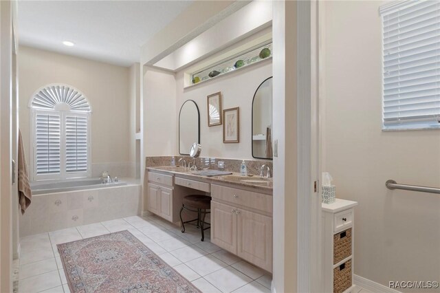 bathroom with a sink, tile patterned floors, double vanity, and a garden tub