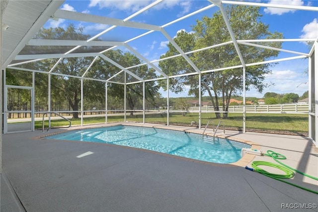 outdoor pool featuring fence, glass enclosure, and a patio