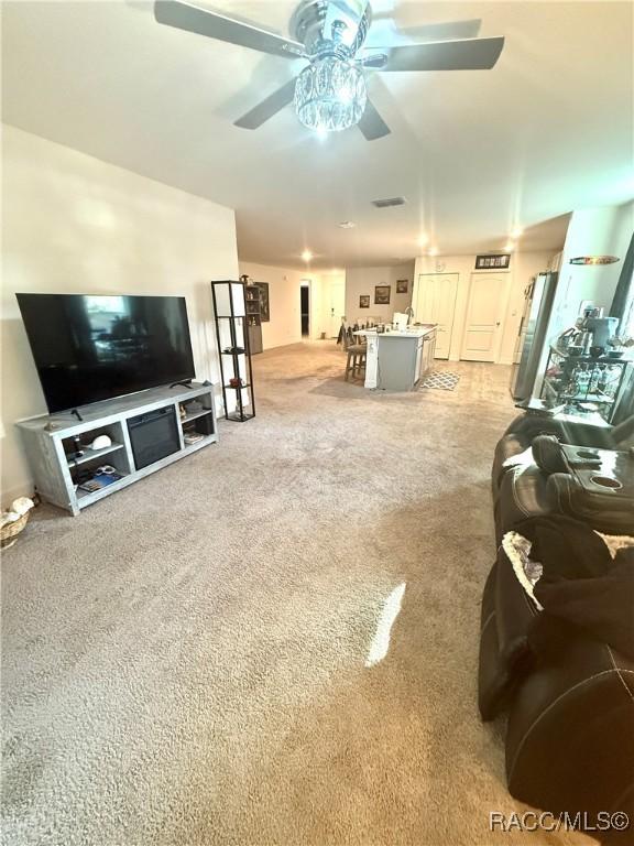 living room featuring light carpet and ceiling fan