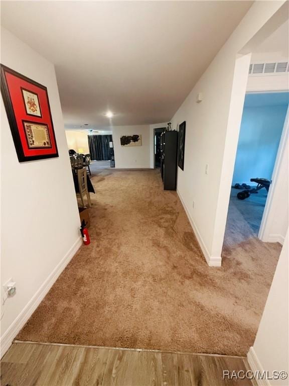 hallway featuring light colored carpet