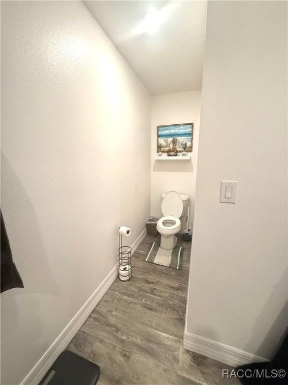 bathroom featuring wood-type flooring and toilet