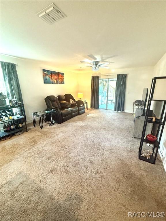 carpeted living room featuring ceiling fan