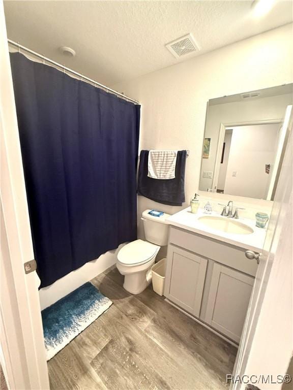 bathroom with vanity, hardwood / wood-style flooring, toilet, and a textured ceiling