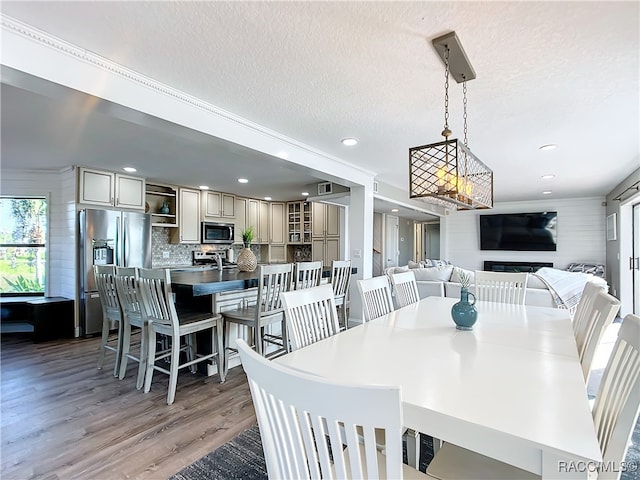 dining area featuring a textured ceiling, wood finished floors, and recessed lighting