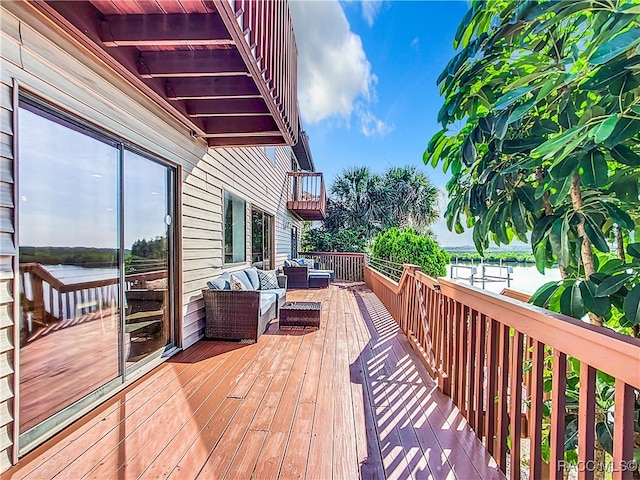 wooden terrace with a water view and an outdoor hangout area