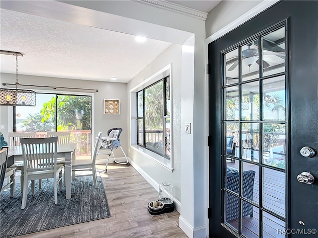 dining room with a textured ceiling, wood finished floors, and baseboards