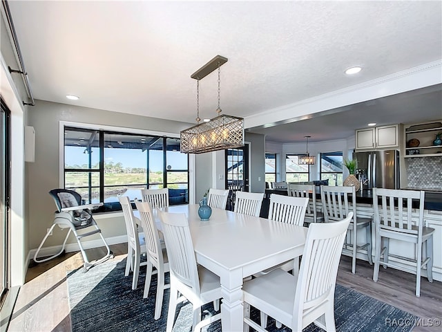 dining room featuring baseboards, recessed lighting, wood finished floors, and a healthy amount of sunlight