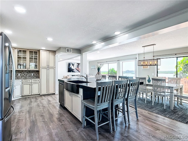 kitchen featuring decorative light fixtures, dark wood-style flooring, appliances with stainless steel finishes, tasteful backsplash, and glass insert cabinets