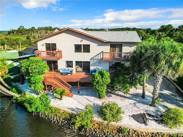 rear view of house with a deck with water view