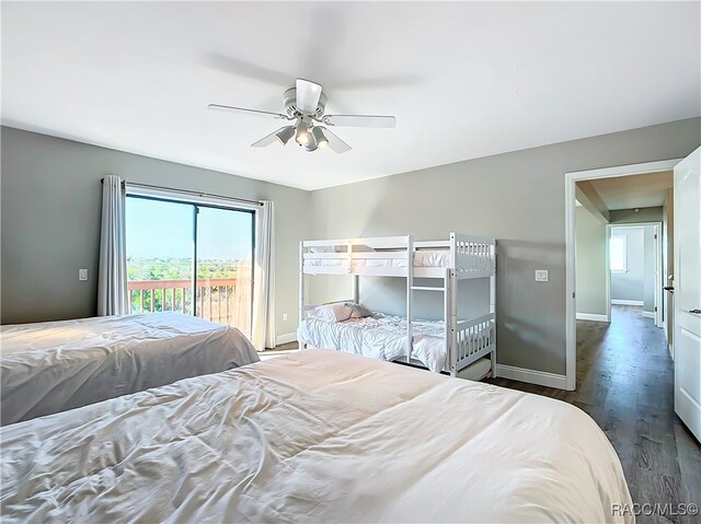 bedroom featuring a ceiling fan, access to outside, baseboards, and dark wood-type flooring