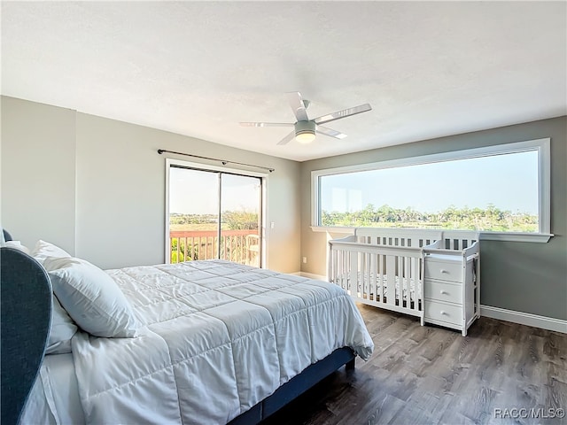 bedroom featuring ceiling fan, access to exterior, multiple windows, and dark hardwood / wood-style flooring