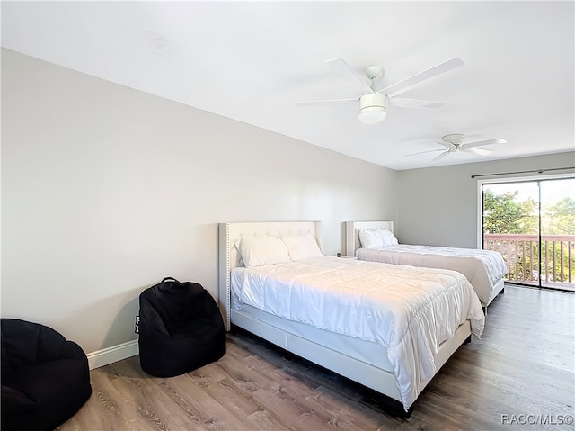 bedroom with dark wood-style floors, ceiling fan, baseboards, and access to exterior