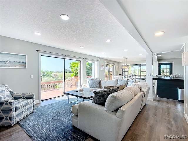 living area with baseboards, wine cooler, wood finished floors, a textured ceiling, and recessed lighting