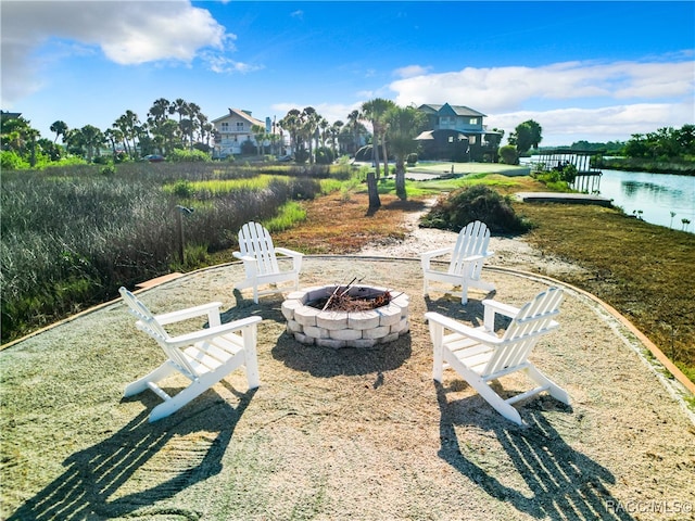 view of yard with a water view and an outdoor fire pit