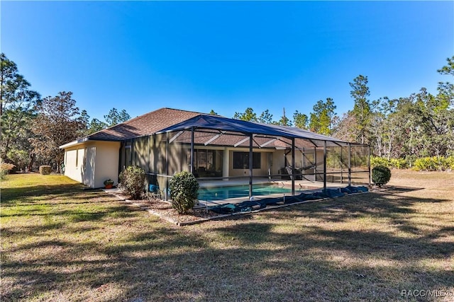 rear view of property featuring a lawn and glass enclosure