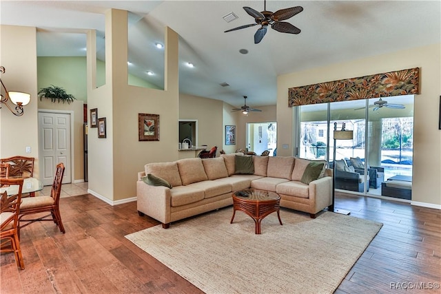 living room featuring hardwood / wood-style flooring, ceiling fan, and high vaulted ceiling