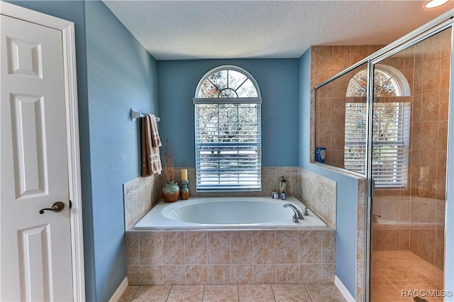 bathroom with tile patterned floors, a textured ceiling, and plus walk in shower