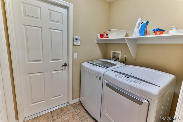 laundry room featuring separate washer and dryer and light tile patterned floors