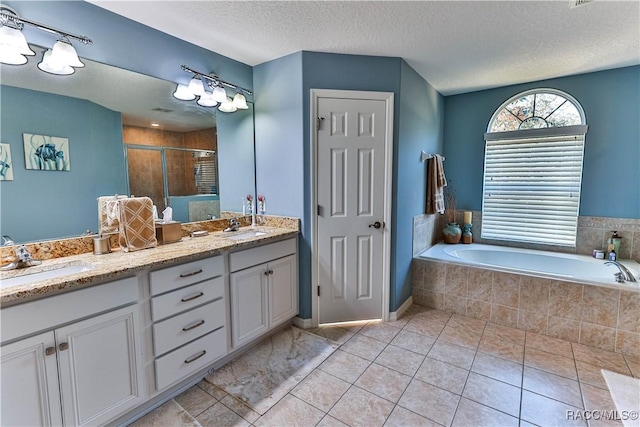 bathroom featuring tile patterned flooring, vanity, separate shower and tub, and a textured ceiling