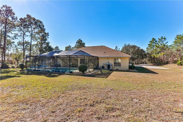 rear view of house featuring central AC, a yard, and glass enclosure