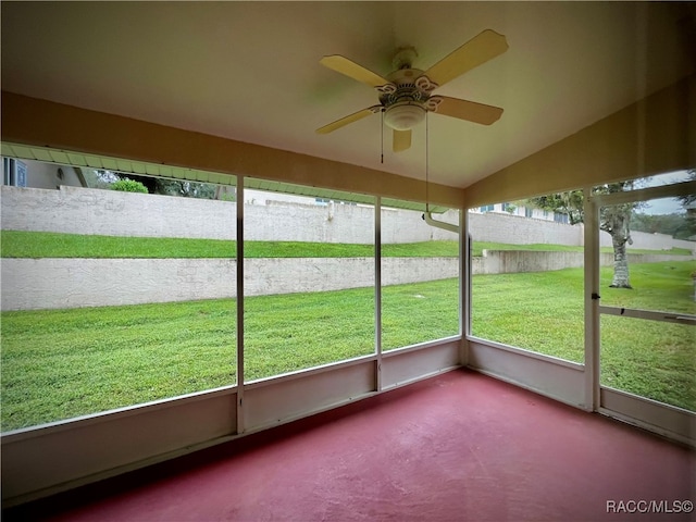 unfurnished sunroom featuring vaulted ceiling, plenty of natural light, and ceiling fan