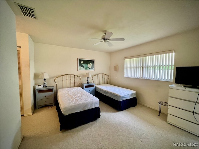 carpeted bedroom with ceiling fan and a closet